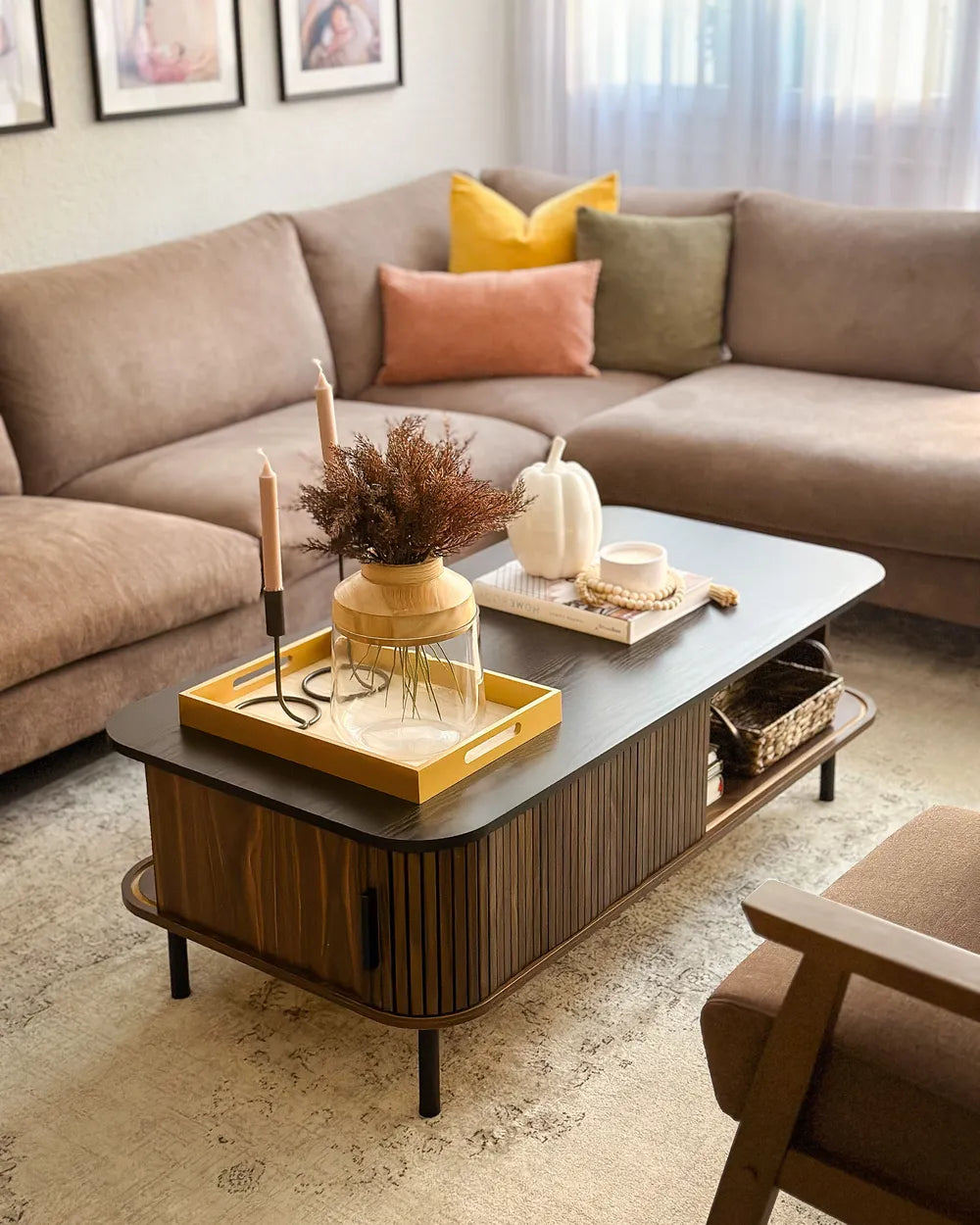The JOSE dark brown coffee table is a rectangular coffee table with built-in storage, designed for modern living rooms. It features sliding doors that provide easy access to concealed storage compartments, as well as two open shelves for everyday items.